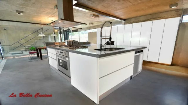 La protagonista es la isla, hormigón a la vista con muebles en color blanco dando realce al espacio.